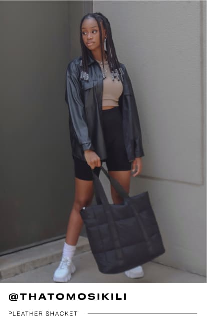 a female Mr Price influencer wearing a black pleather shacket and cycle shorts with a nude active top and white socks with sneakers
