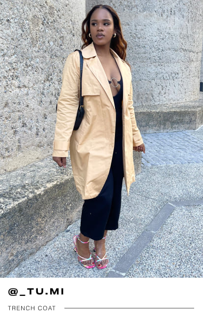 a female Mr Price influencer in a beige trenc coat with a black bodycon dress and pink heels