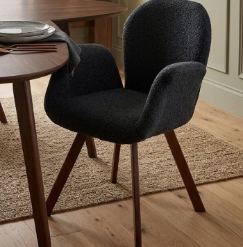 Mid-century modern dining chairs with emerald green velvet upholstery and tapered wooden legs.