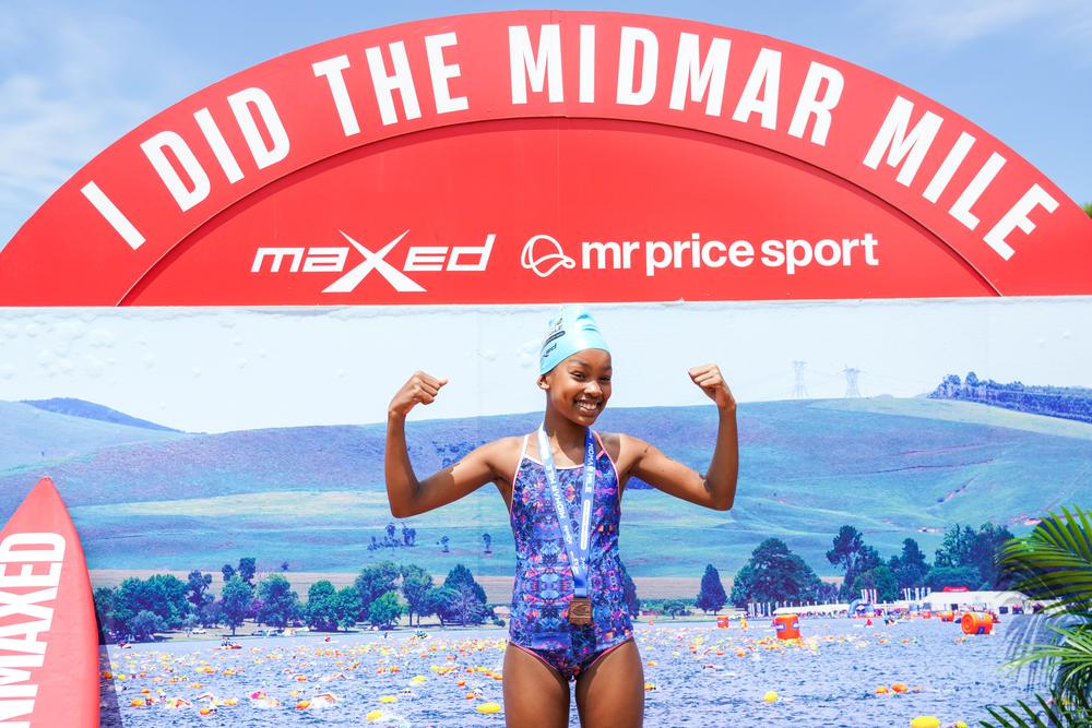 Young swimmer flexing both arms on the podium